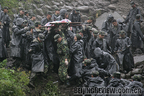 TO THE RESCUE: Soldiers from the Chengdu Military Area Command repair roads leading to the hardest-hit areas and evacuate survivors to safer areas LIU YINGHUA