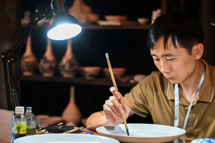 景德镇传统粉彩瓷制作技艺市级非遗代表性传承人黄孝青正在现场展示技艺。.jpg