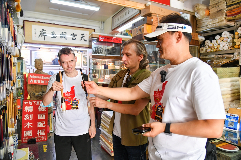 导游正在教外国记者毛笔的拿笔姿势_109210.jpg