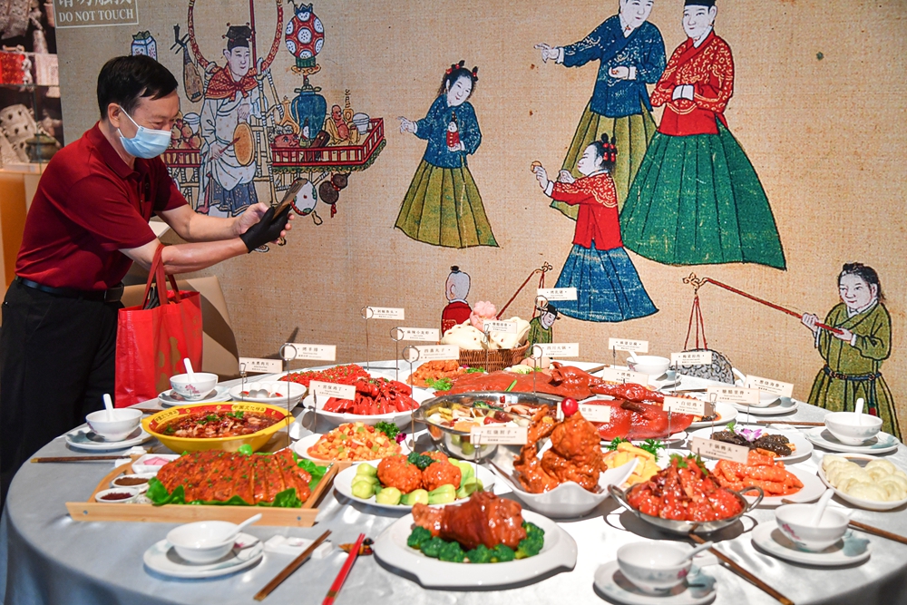 一名观众在拍摄展出上陈列的中国各地的名菜_106458.jpg