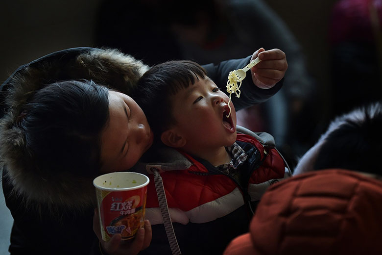 2016年1月28日，合肥火车站候车大厅，一位母亲在喂孩子方便面。江雨摄.jpg