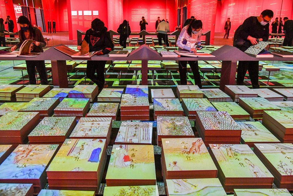 观众正在展厅中翻阅《中国历代绘画大系》图书_110557.jpg