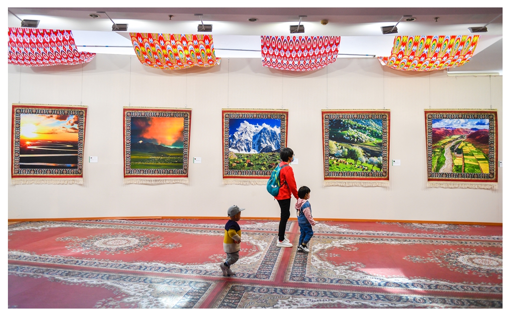 观众正在欣赏自然风光照片，这组照片印在新疆特色的毛绒挂毯上展_089847.jpg