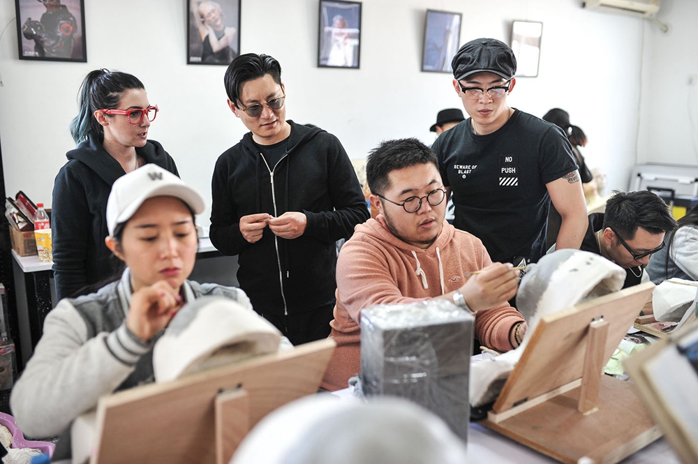 Xiao Jin (center) and American teacher Nicole Chilelli assess trainees' work.jpg