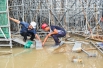 10 2017年8月22日，裴睿（左）正在工地的积水处和同事搭建简易踏板。.jpg