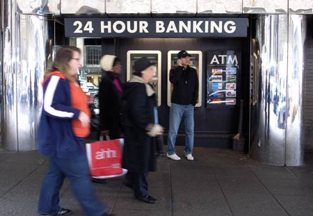 People walk past an ATM on a street in Manhattan, New York, the United States, April 23, 2009. President Obama said on Thursday he will push for a law to provide "strong and reliable" protections for millions of Americans who have credit cards after meeting with chief executives of credit-card leading industry. (Xinhua/Liu Xin)