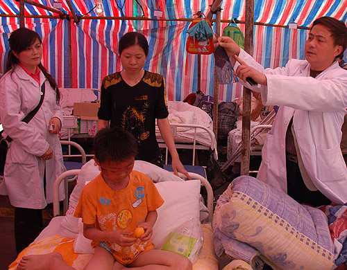 A doctor explains the nature of a boy’s wounds inside a makeshift hospital tent in Dujiangyan HUANG WEI/BEIJING REVIEW 