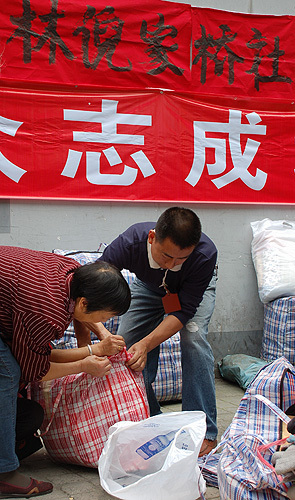 Staff (L) helps a donor to pack the clothes. HUANG WEI/BEIJING REVIEW
