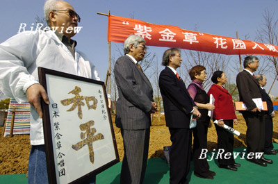 RIENDSHIP BETWEEN PEOPLES: Japanese visitors hold a frame with the Chinese character for “peace” on it on March 28, while attending a foundation ceremony of Zijincao Park in Nanjing, China’s Jiangsu Province.