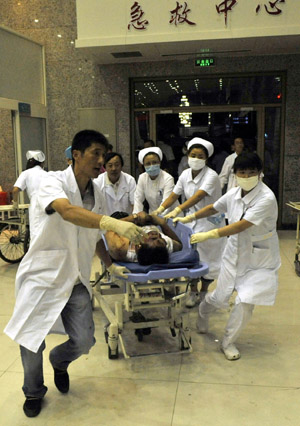 An injured man is carried to an urgent care center in Urumqi, capital of northwest China's Xinjiang Uygur Autonomous Region on July 5, 2009.