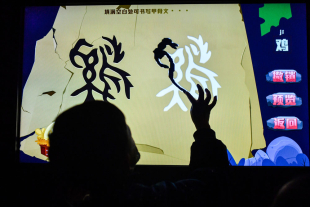 小观众正在多媒体展台上尝试书写“鸡”字的甲骨文_120684.jpg