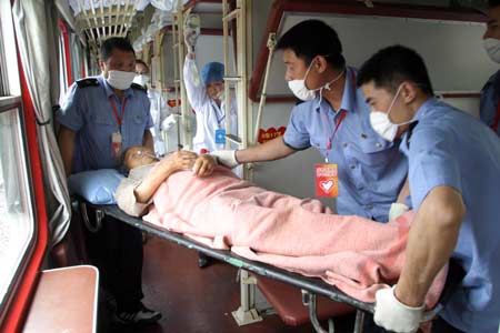 People carry an injured in the train at the Jiangyou Railway Station in Jiangyou, southwest China's Sichuan Province, May 21, 2008. More than 300 people injured in the May 12 quake hitting Sichuan were transferred by a special train to Kunming, capital of southwest China's Yunnan Province, on May 21. 